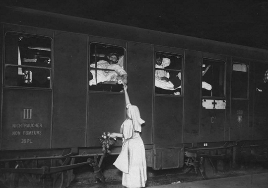 First World War. Geneva. Repatriation of seriously wounded soldiers from France, who were detained in Germany. Medical personnel of the Swiss Red Cross is attending to them outside the train. ICRC audiovisual archives / R. Gilli / V-P-HIST-00323-2